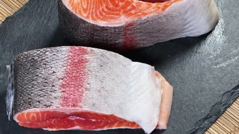 Pieces of raw rainbow trout on flat black slate plate Stock Footage 342276966