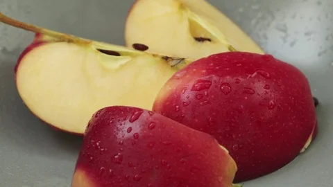 Pieces of red apple on grey plate Stock Footage 80375302