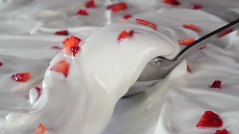 Pieces of red strawberries close-up in on white yogurt. Stock Footage 175151722