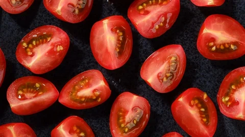 Pieces of red tomatoes on black plate rotating. top view Stock-Footage 130063545