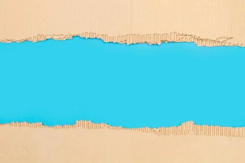 Pieces of ripped cardboard on a blue background with copy space Foto stock