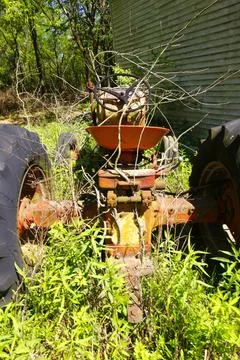 Pieces of Rusting Junk Surrounded by Weeds Stock Photos