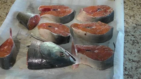Pieces of Salmon Are Lying on Dripping Pan on Paper For Baking Stock Footage 65264335