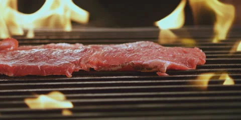 Pieces of steak falling on grill Stock Footage 247385169