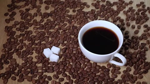 Pieces of sugar fall into a cup of black coffee Stock Footage 140707542