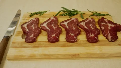 Pieces of thinly sliced cured meat on a wooden board Stock Footage 319418803