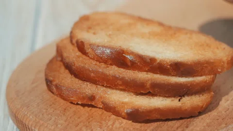 Pieces of toasted bread are laid out on a kitchen board Stock Footage 160910209