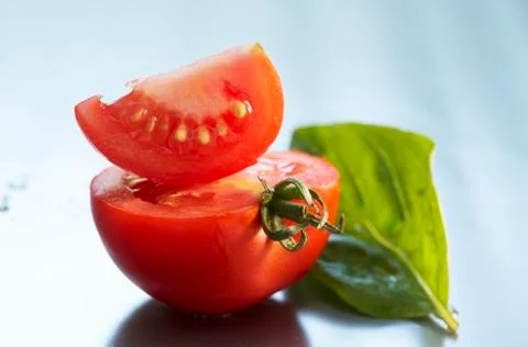 Pieces of tomato with a basil leaf Stock Photos