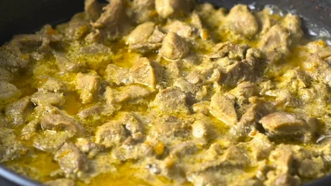 Pieces of turkey meat are fried in a pan in a creamy sauce. Close-up 4k video. Stock Footage 70497464