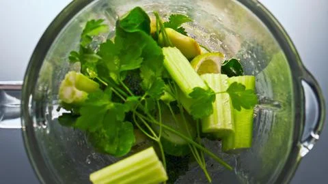 Pieces vegetables inside blender preparing in super slow motion closeup. Stock Photos