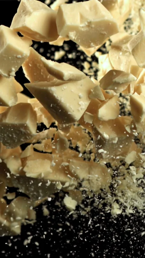 Pieces of white chocolate fly up and fall down. Filmed on a high-speed camera at Stock Footage 335358057