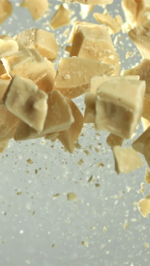 Pieces of white chocolate fly up and fall down. Filmed on a high-speed camera at Stock Footage 335358207