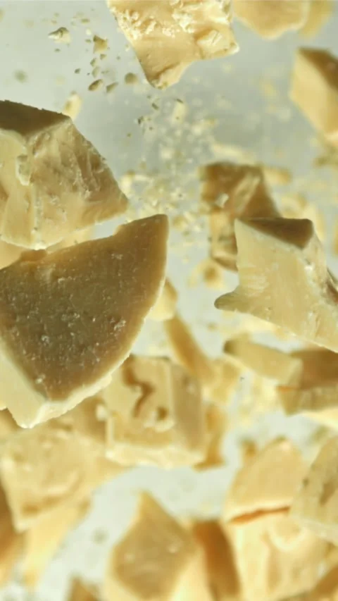 Pieces of white chocolate fly up and fall down. Filmed on a high-speed camera at Stock Footage 335360127