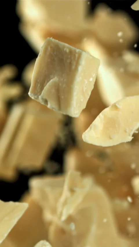 Pieces of white chocolate fly up and fall down. Filmed on a high-speed camera at Stock Footage 335360559