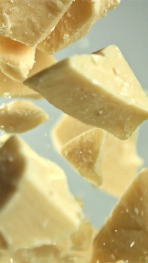 Pieces of white chocolate fly up and fall down. Filmed on a high-speed camera at Stock Footage 335361207