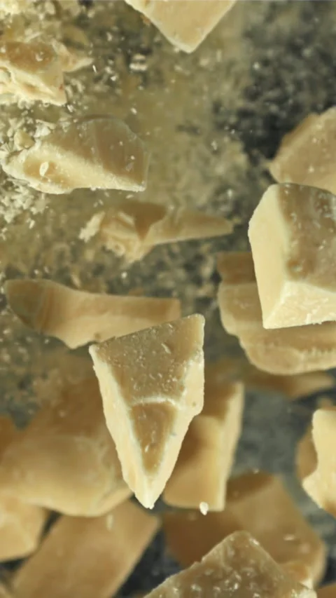 Pieces of white chocolate fly up and fall down. Filmed on a high-speed camera at Stock Footage 335362031