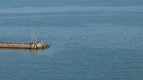 Pier extending into calm blue sea water Stock Footage 336690705