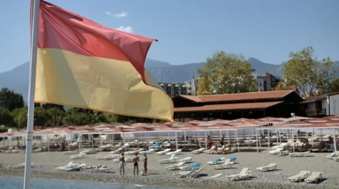 Pier with a lifeguard flag fluttering in a light breeze of Mediterranean sea Video stock 69000803