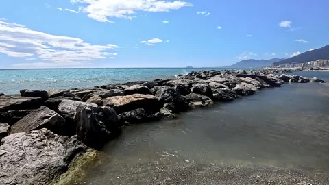 A pier made of large rocks protects the shoreline from incoming sea waves, creat Video stock 331943011