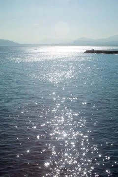 Pier with reflections of the sun on the sea Stock Photos
