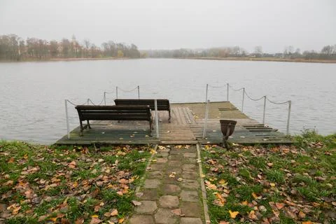 A pier on the river in the fall with a bench. Stock Photos