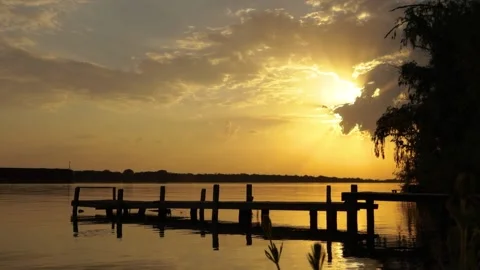 Pier on the river with sunset as a backdrop Stock Footage 236106368