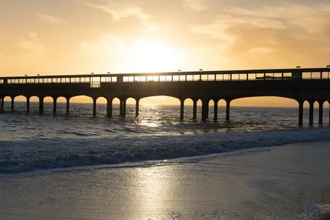 Pier At Sunset With Waves Breaking Stock Photos