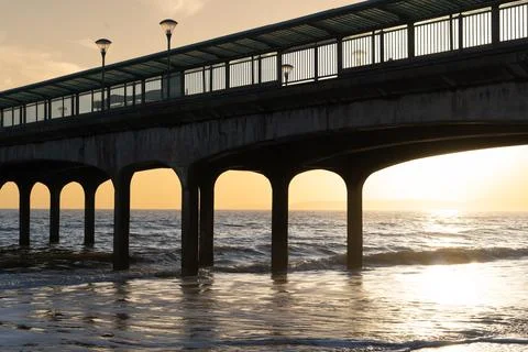 Pier At Sunset With Waves Breaking Stock Photos