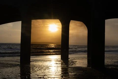Pier At Sunset With Waves Breaking Stock Photos