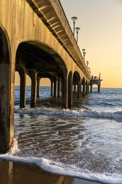 Pier At Sunset With Waves Breaking Stock Photos