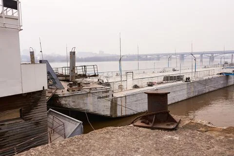 Pier with a view of an old barge. Stock Photos