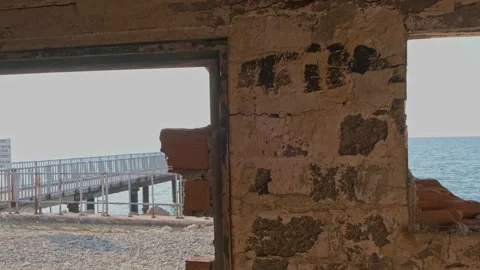 Pier view through derelict house window by the beach Stock Footage 234701794