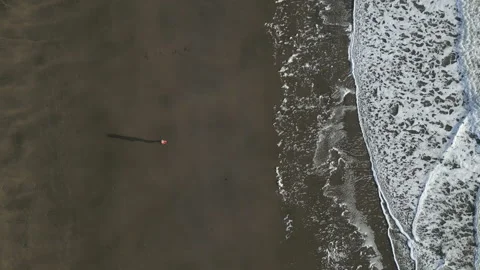 A pier is visible on the beach with a large building in the background Stock Footage 298273210
