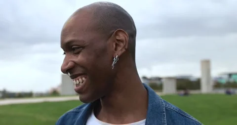 Pierced african man smiling on camera at city park Stock Footage 192384254