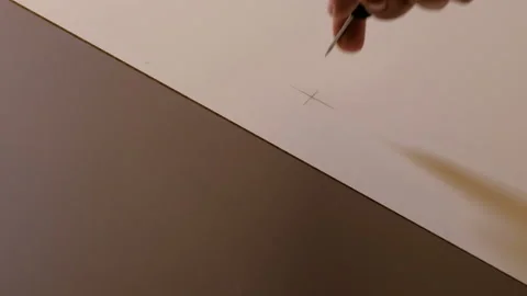 Piercing a hole with an awl in white and brown chipboard for making furniture. M Stock Footage 116647121