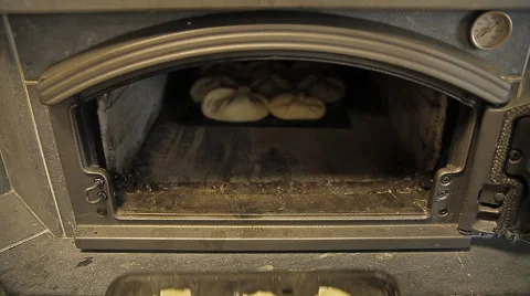 The pies on a baking tray are put into the furnace for baking Stock Footage 58053181