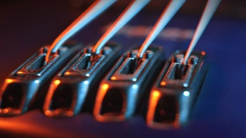 Piezo bridge, output and knobs of a fretless electric bass guitar, warm lighting Stockbeeldmateriaal 114062093