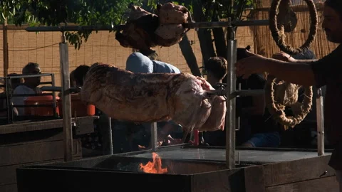 A pig carcass is roasted on a spit in the medieval festival. The pig carcass is Stock Footage 248389213