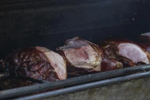 The pig on the spit is grilled on an open fire. Stock Photos