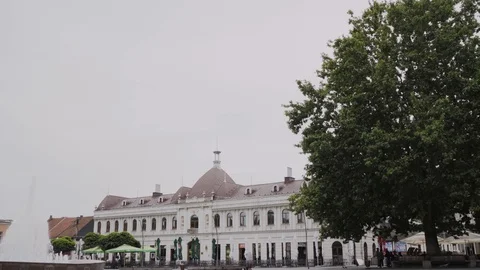 Pigeons fly over Trg Slobode, Tuzla, Bosnia Herzegovina, pan left, Rec709 Stock Footage 93259200