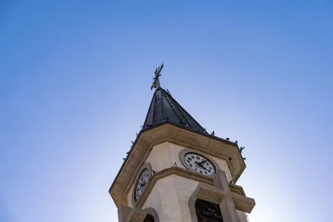 Pigeons perched on the clock tower of Ermita de Nuestra Senora de Bonanza Photos