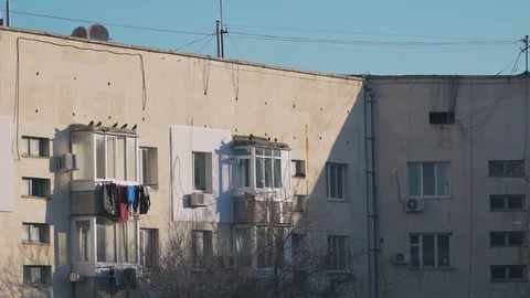 Pigeons sit on the roofs of the balconies of the multi-storey huge building and  Stock Footage 128016877