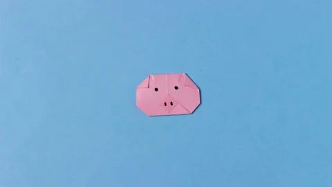 Pig's head is folded from pink paper origami with painted mustache. Stock Footage 156349632