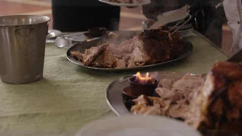Pig's leg flomber. Waiters slice freshly baked sizzling pork meat in the Stock Footage 248431041