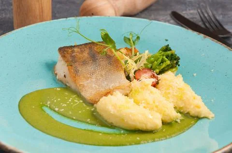 Pike perch with mashed potatoes on a blue plate Stock Photos