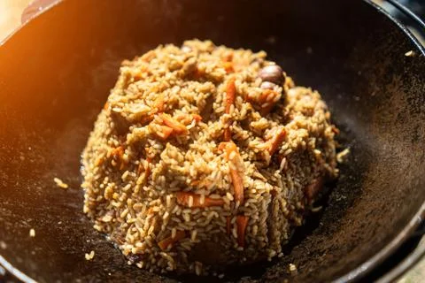 Pilaf in a cauldron in close-up. Stock Photos