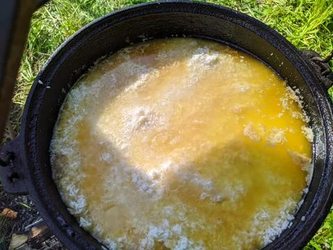 Pilaf in a cauldron on an open fire in the daytime in summer. Stock Photos