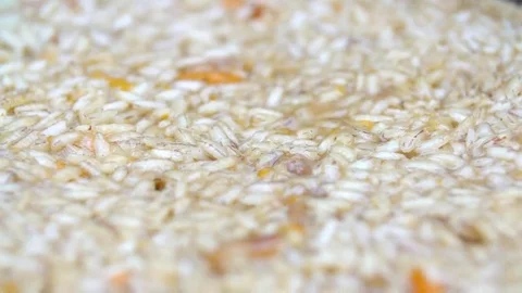Pilaf in a cauldron over a fire. Rice and carrot. Close-up. Macro Stock Footage 69206511