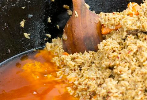 Pilaf in a cauldron with spoon Stock Photos