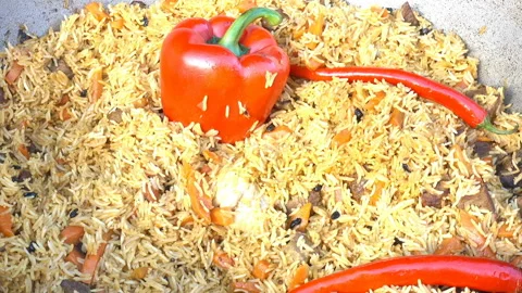 Pilaf with red pepper in a large cauldron. Stock Footage 126606636